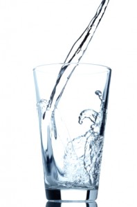 Pouring water into glass isolated on white background Drink plenty of water